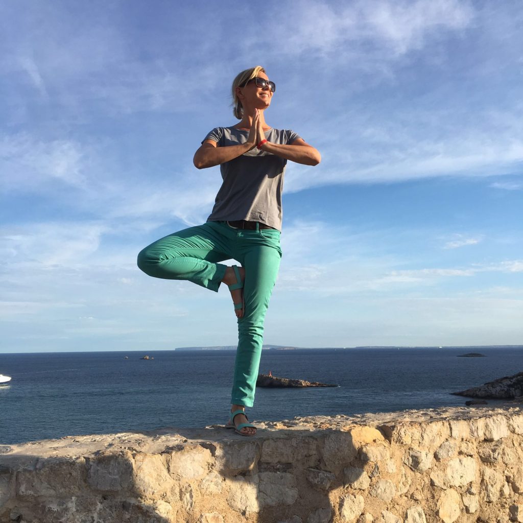 Elke in der Baum Position auf der Stadtmauer von Eivissa auf Ibiza