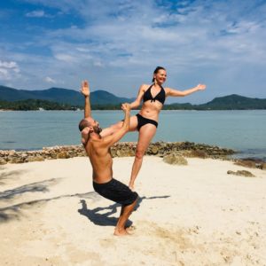Zwei Menschen beim Acro Yoga am Strand