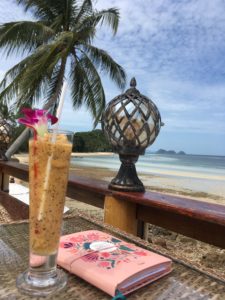 Ein Cocktail und ein Tagebuch mit Blick auf den Strand
