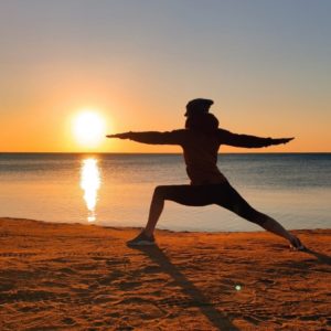Elke in der Krieger Position bei Sonnenaufgang am Strand in Soma Bay
