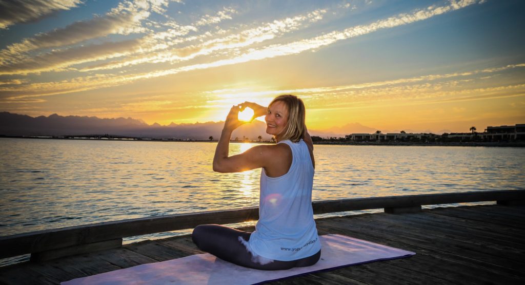 Elke auf dem Jetty sitzend bei Sonnenuntergang