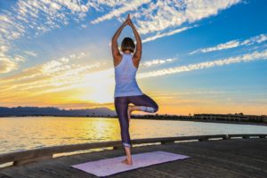 Elke in der Baum Position bei Sonnenuntergang auf dem Jetty in Soma Bay
