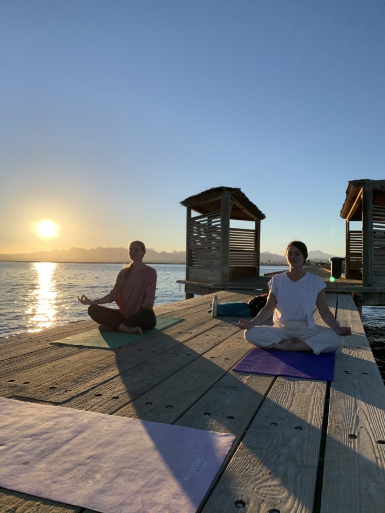 Yoga auf dem Jetty mit Sonnenuntergang